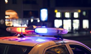 Blue light flasher atop of a police car. City lights on the background for a police misconduct attorney in ohio