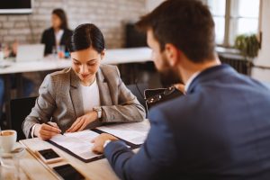 A women signing an employment contract after consulting with a Columbus employment attorney.